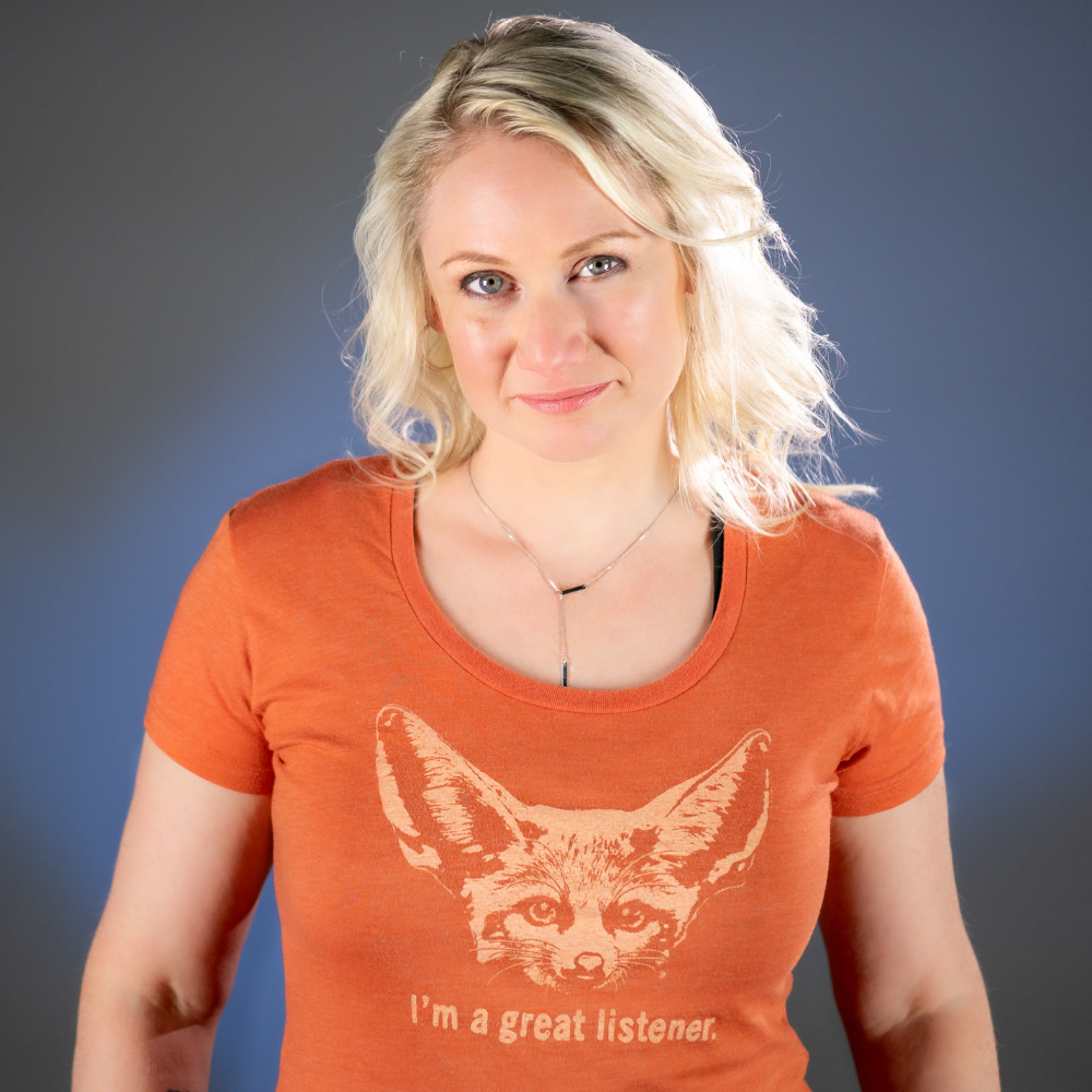 Justine wears an orange shirt with a fox on it that says I'm a great listener.